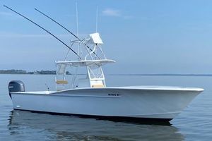 Custom Carolina Forbes Custom Carolina Forbes 2025 boat on calm water with fishing rods and clear sky.