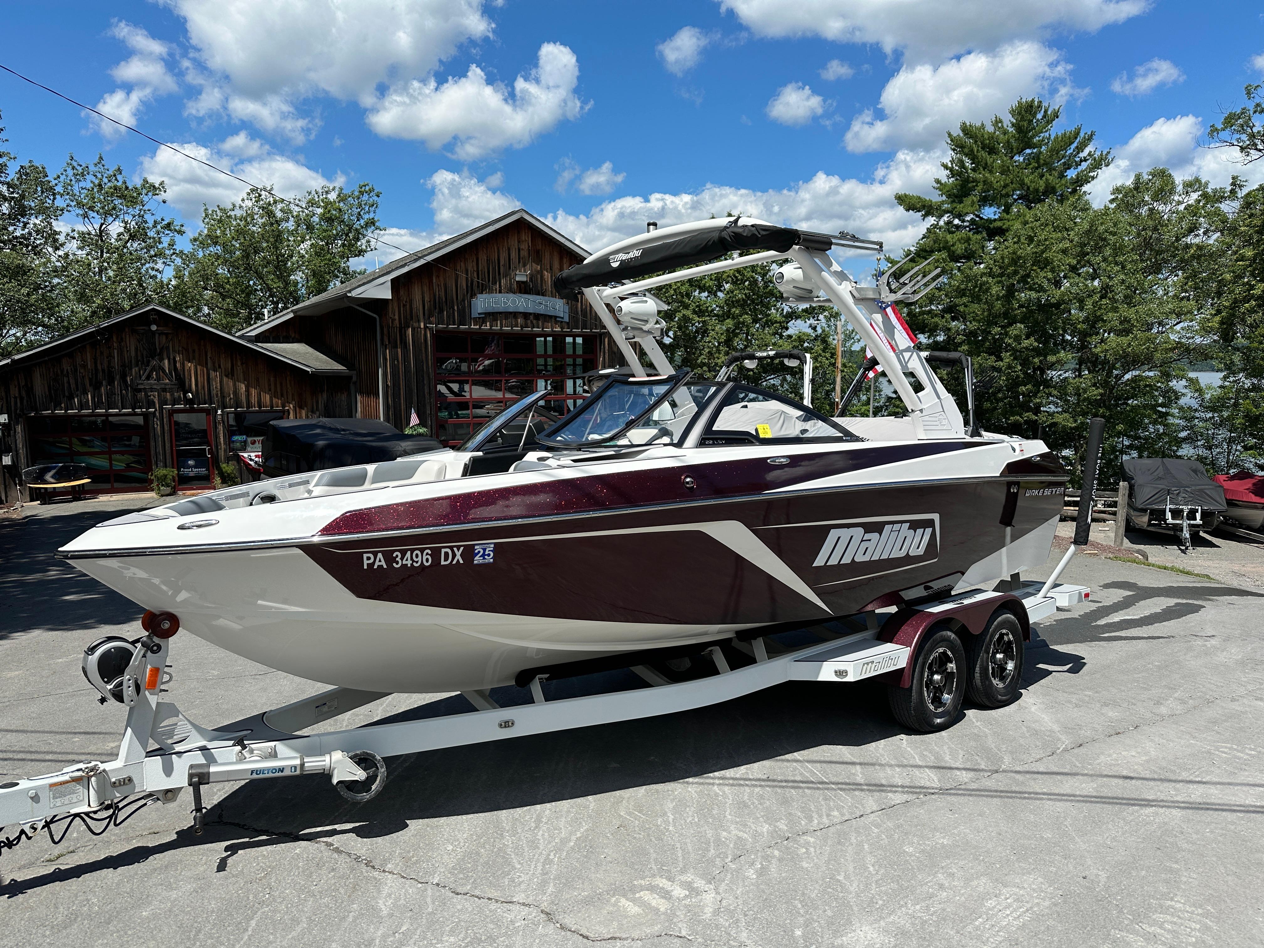Malibu Wakesetter 22 LSV 2019 Malibu Wakesetter 22 LSV boat on trailer, parked outdoors under blue sky.