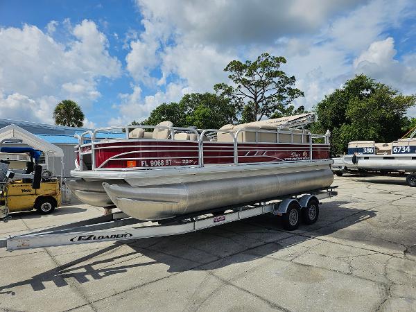 Sun Tracker Fishin' Barge 20 DLX 2021 Sun Tracker Fishin' Barge 20 DLX pontoon boat on trailer, outdoors.