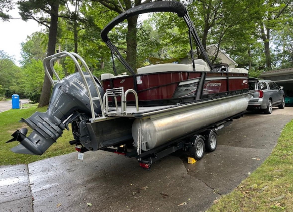 Starcraft SLS-3 2020 Starcraft SLS-3 pontoon boat on trailer, parked in driveway with trees in background.