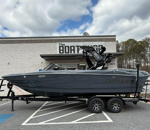 Centurion NV233 2025 Centurion NV233 boat on trailer outside dealership, under cloudy sky.