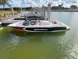 MasterCraft ProStar 2021 MasterCraft ProStar boat docked on a sunny day, featuring sleek design and vibrant colors.