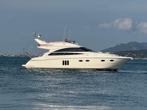 Princess 54 Luxurious 2010 Princess 54 yacht cruising on calm waters with scenic mountain backdrop.