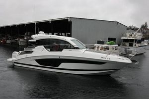 Four Winns V355 Coupe OB 2021 Four Winns V355 Coupe boat docked in a marina on a cloudy day.
