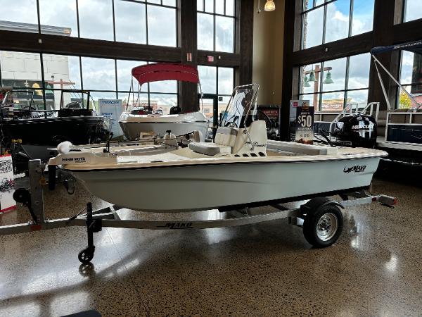Mako Pro Skiff 13 CC 2025 Mako Pro Skiff 13 CC boat displayed indoors on a trailer.