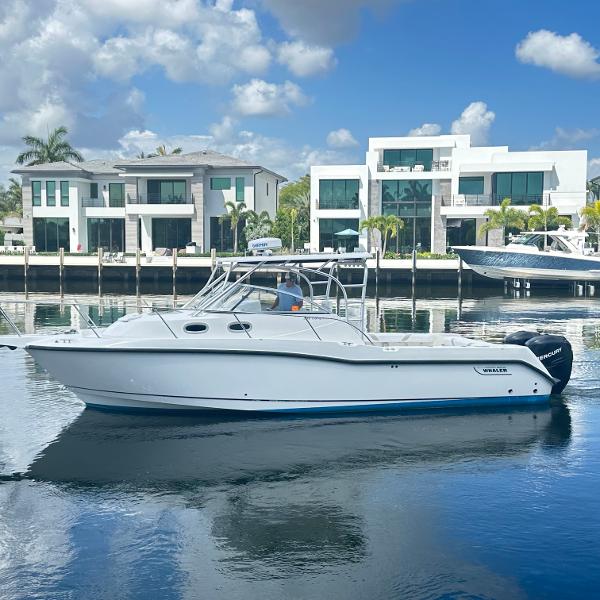 Boston Whaler 305 Conquest 2006 Boston Whaler 305 Conquest boat on calm water, modern waterfront homes in background.