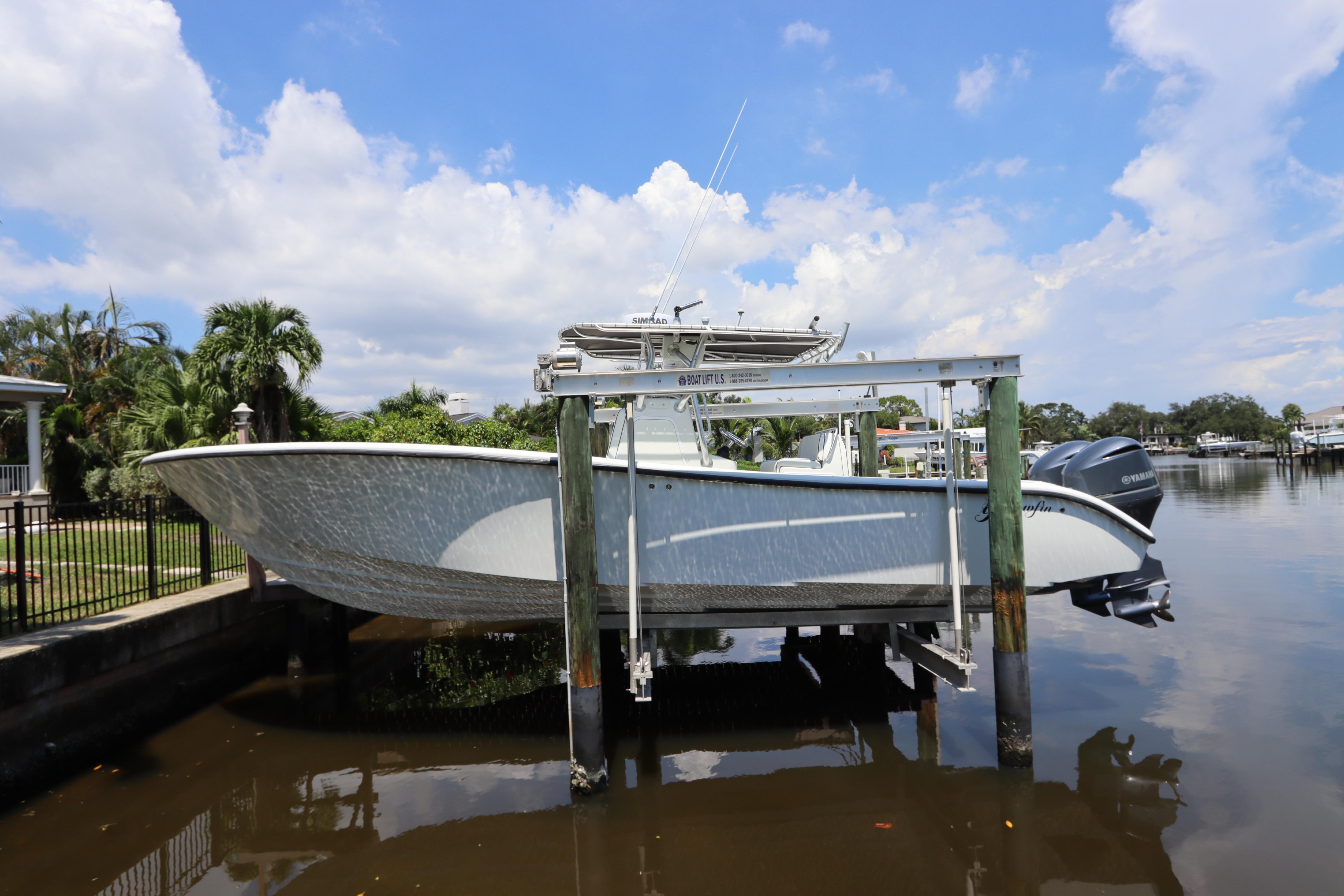 Yellowfin 32 Offshore 2013 Yellowfin 32 Offshore boat on lift, docked by a scenic waterfront.