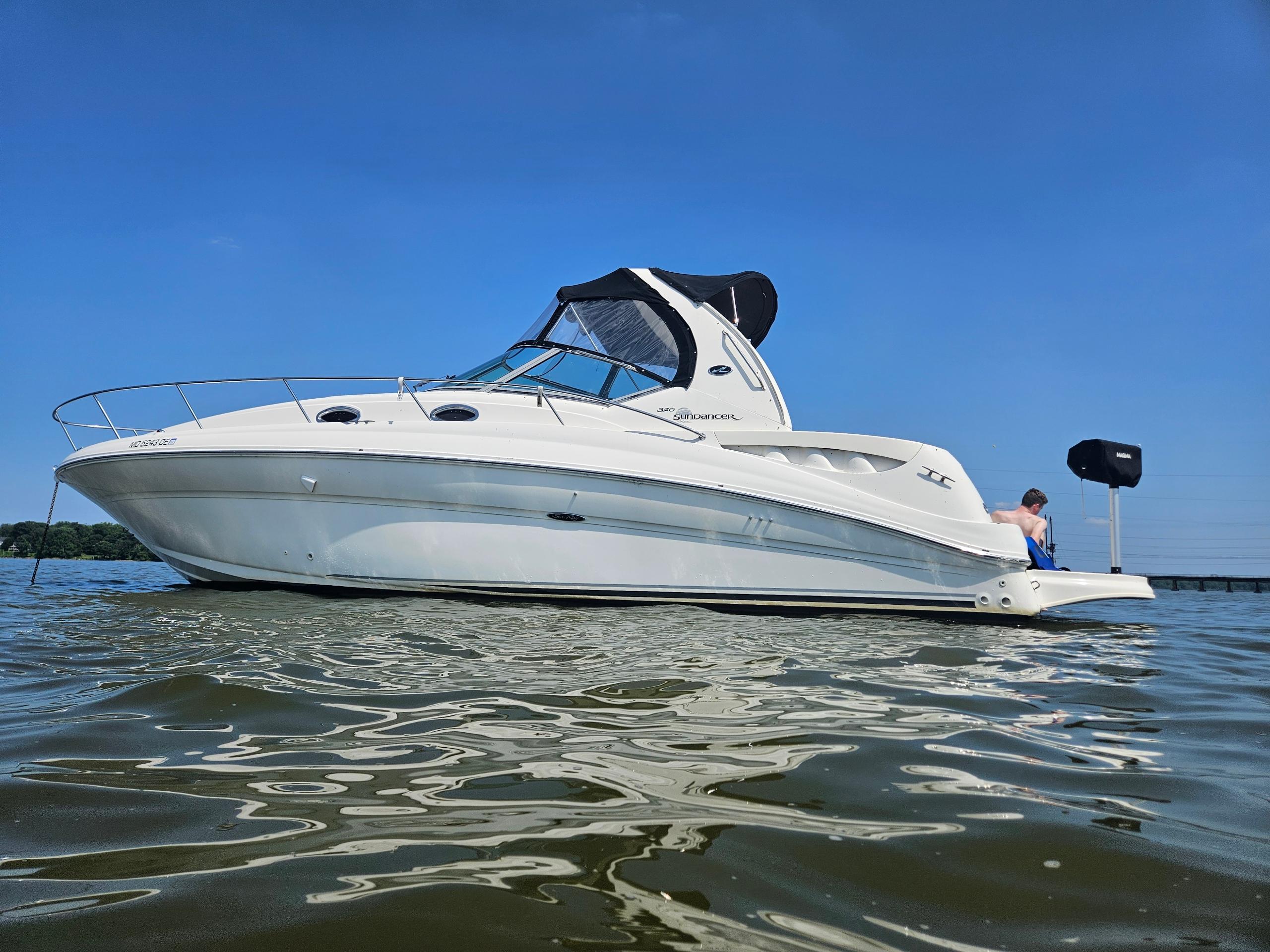 Sea Ray 320 Sundancer 2004 Sea Ray 320 Sundancer yacht on calm water under clear blue sky.