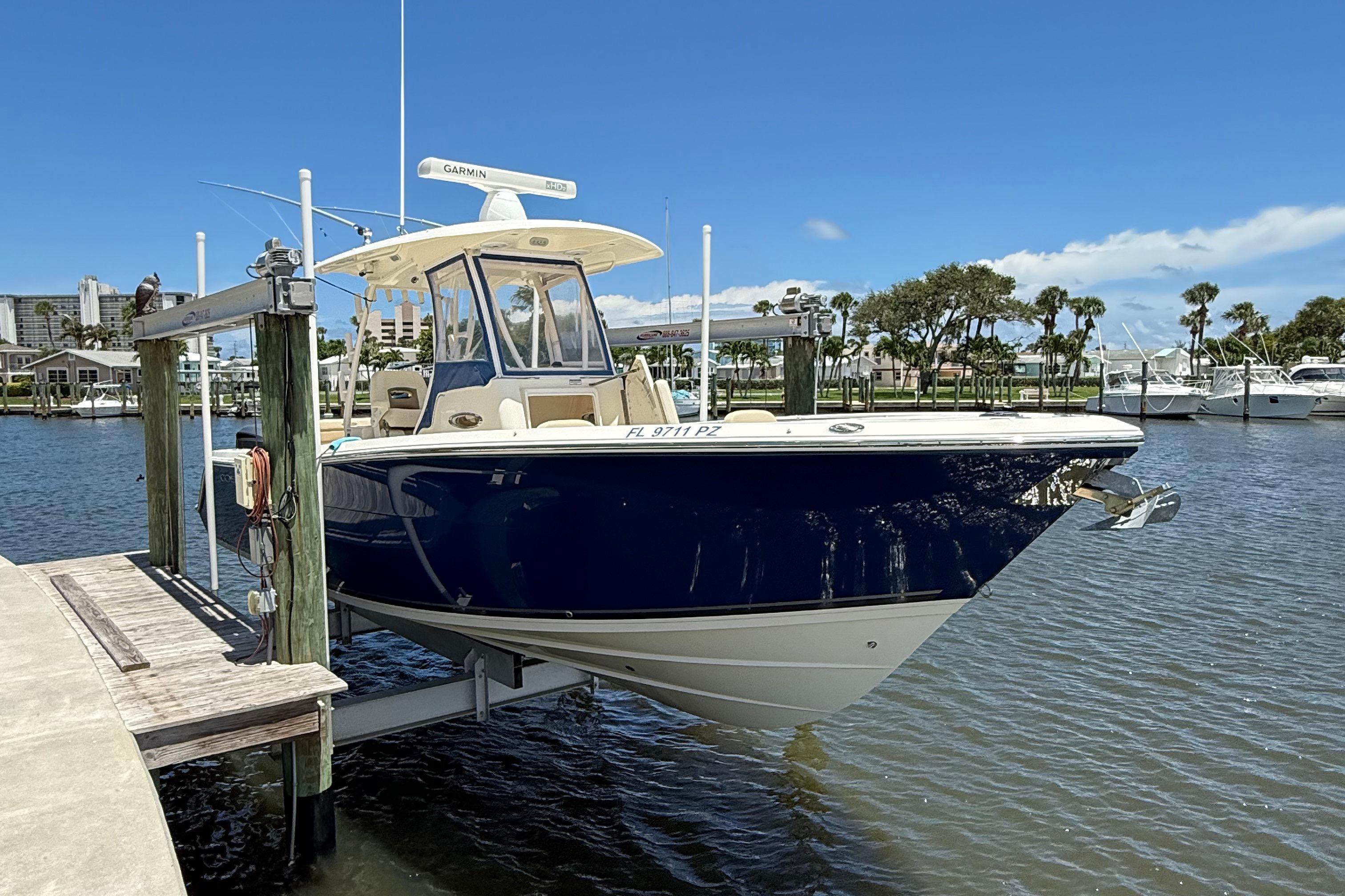 Cobia 296 Center Console 2015 Cobia 296 Center Console boat docked at marina under clear blue sky.