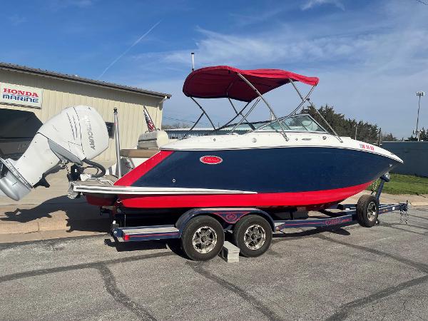 Cobalt 23 SC 2019 Cobalt 23 SC boat with red canopy on trailer, parked near Honda Marine building.