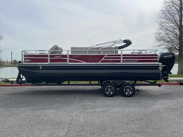 Ranger Reata 220F 2024 Ranger Reata 220F pontoon boat on trailer, parked near a lake.
