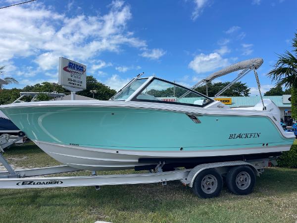 Blackfin 232DC 2024 Blackfin 232DC boat on trailer under blue sky.
