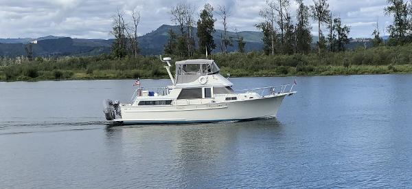 Tollycraft 43 1981 Tollycraft 43 Motoryacht cruising on a serene lake with forested hills in the background.