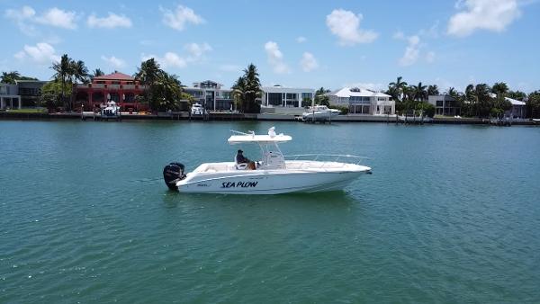 Boston Whaler 320 Outrage 2008 Boston Whaler 320 Outrage boat named Sea Plow on calm water near waterfront homes.