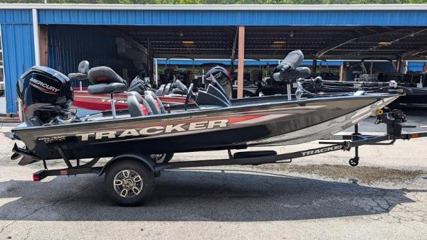 Tracker Pro Team 175 2025 Tracker Pro Team 175 boat on trailer, parked outside a blue building.