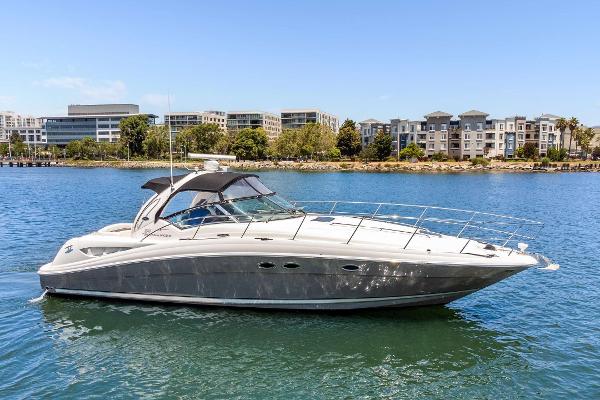 Sea Ray 390 Sundancer 2005 Sea Ray 390 Sundancer yacht cruising on a sunny day near waterfront buildings.