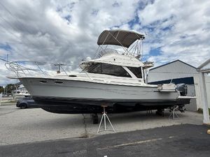 Cutwater C-32 CB 2023 Cutwater C-32 CB boat on stands, under cloudy sky, in a marina setting.