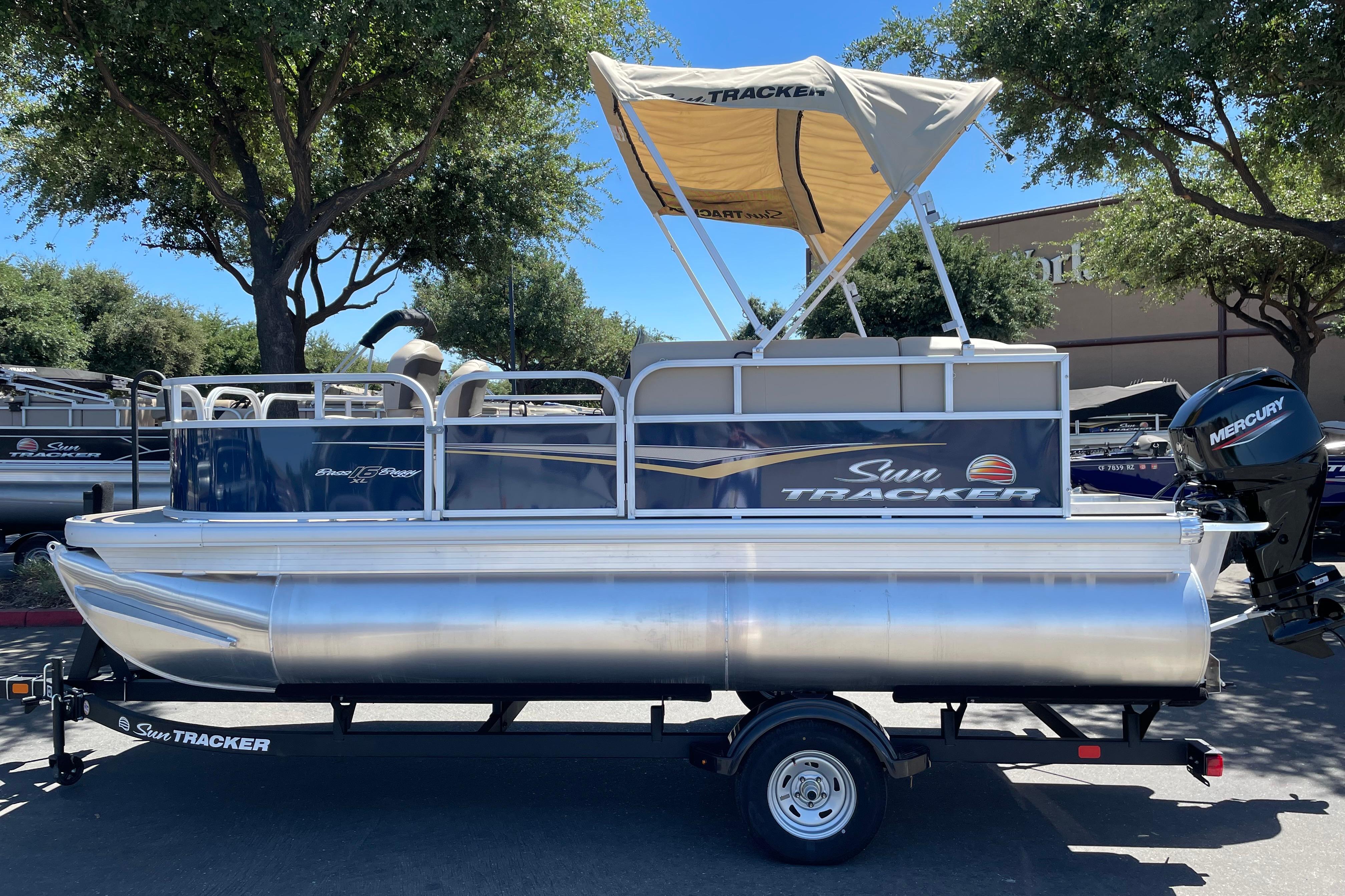 Sun Tracker Bass Buggy 16 XL Select 2025 Sun Tracker Bass Buggy 16 XL Select pontoon boat with canopy on trailer.