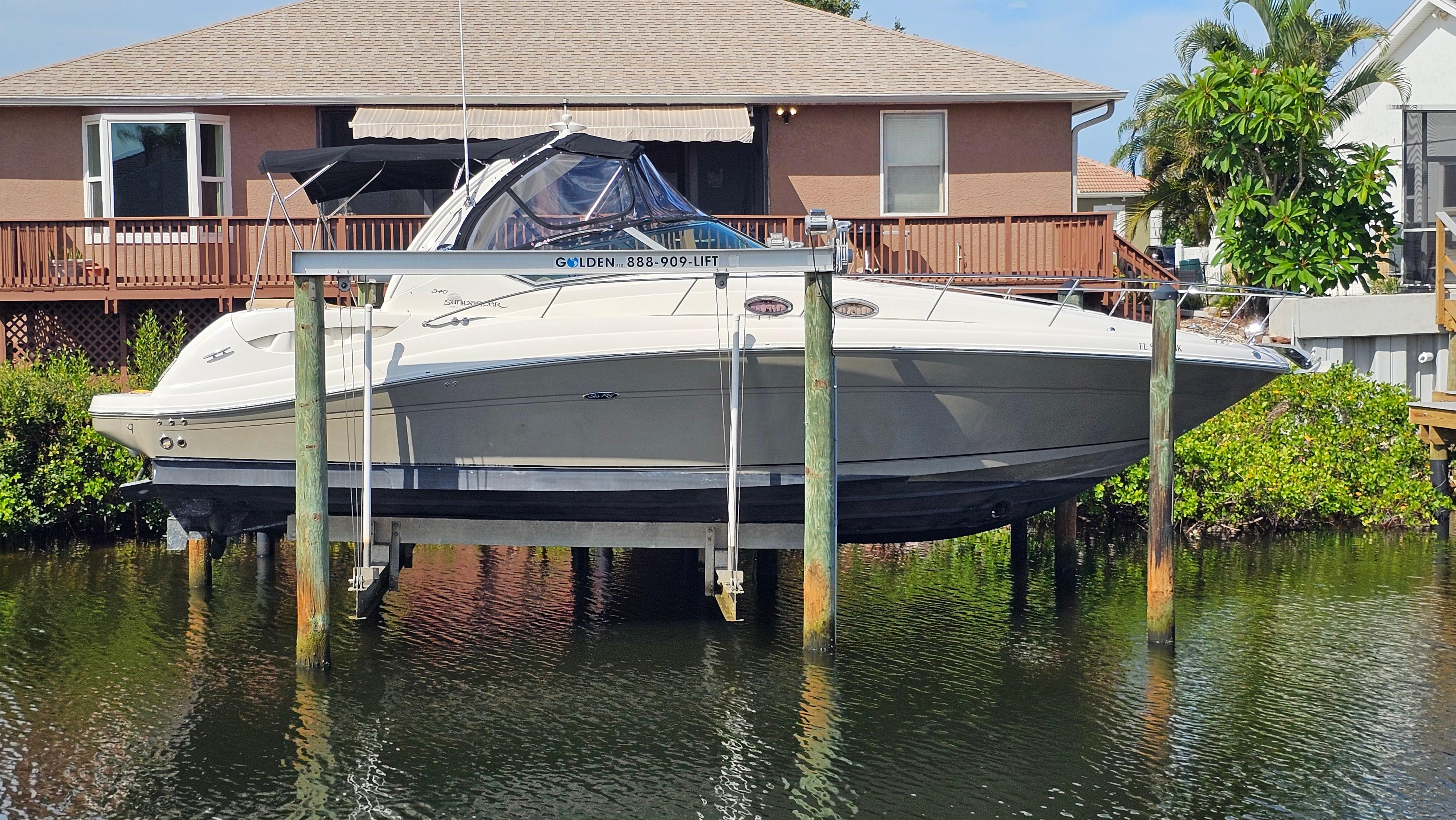 Sea Ray 340 Sundancer 2007 Sea Ray 340 Sundancer boat on lift near waterfront home.