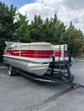 Sun Tracker Party Barge 18 DLX 2025 Sun Tracker Party Barge 18 DLX pontoon boat on trailer, parked outdoors.