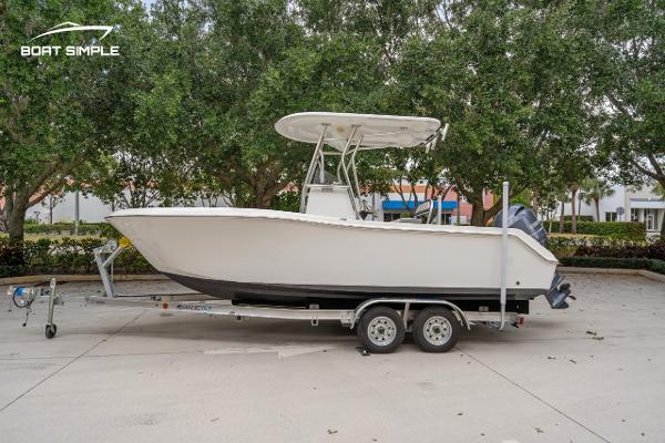Release 210 RX 2020 Release 210 RX boat on trailer, parked outdoors with trees in background.