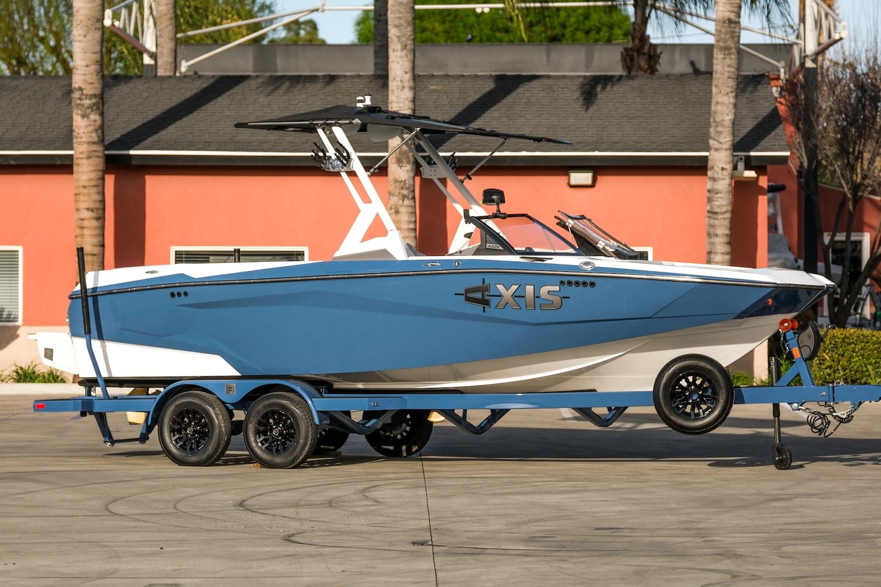 Axis A225 2024 Axis A225 boat on trailer, blue and white design, parked outdoors.