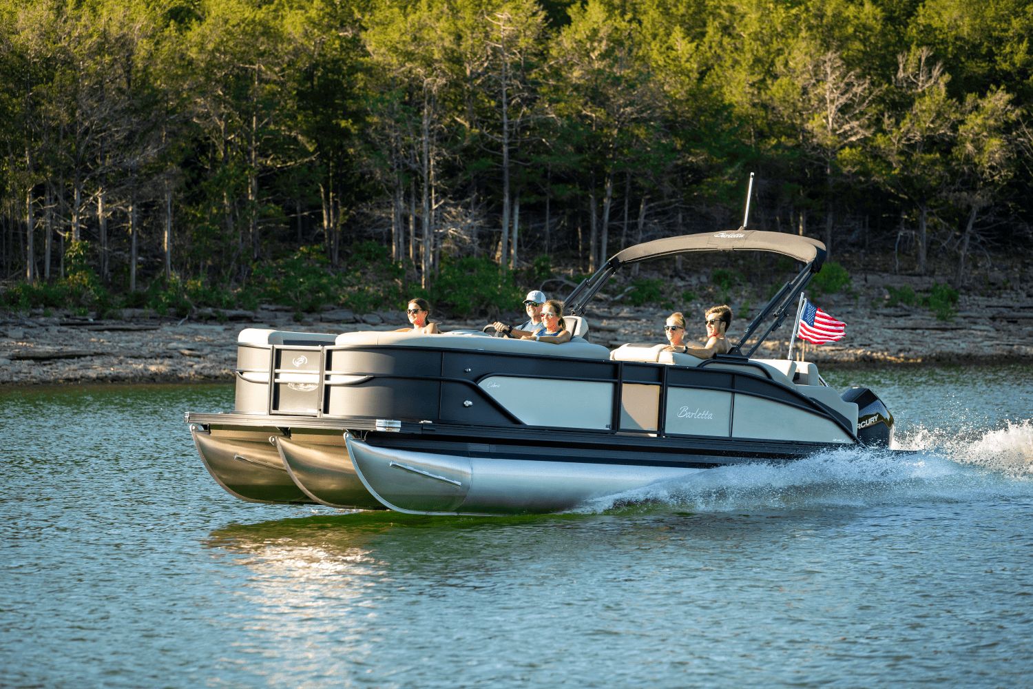 Barletta Cabrio 22 U 2026 Barletta Cabrio 22 U pontoon boat cruising on a lake with passengers.