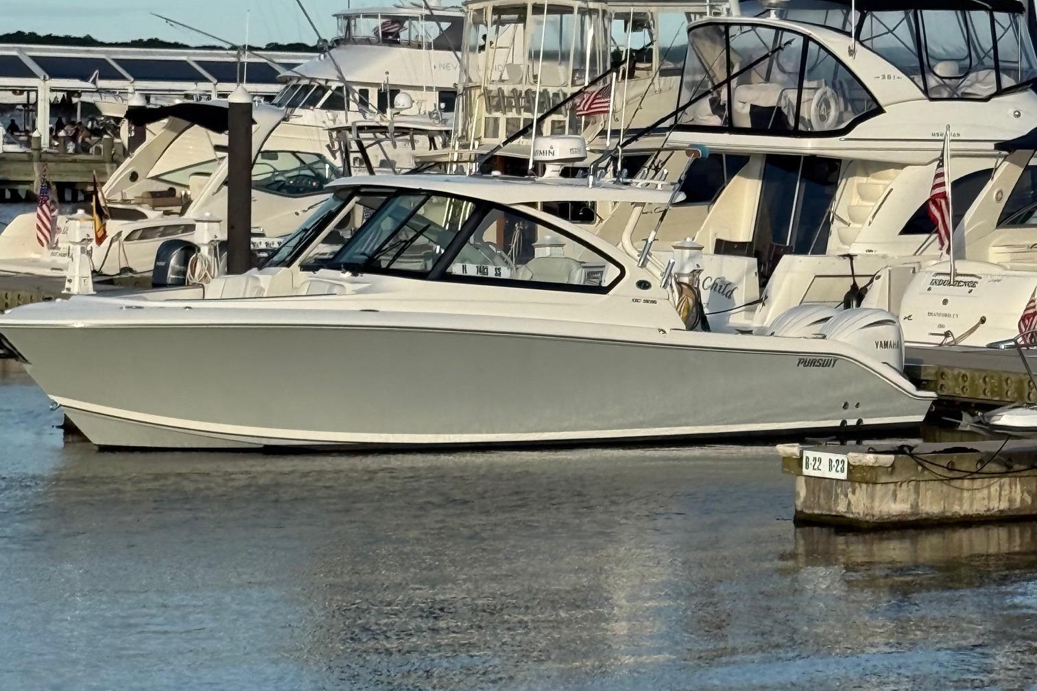 Pursuit DC 306 Dual Console 2024 Pursuit DC 306 Dual Console boat docked at marina with other yachts.