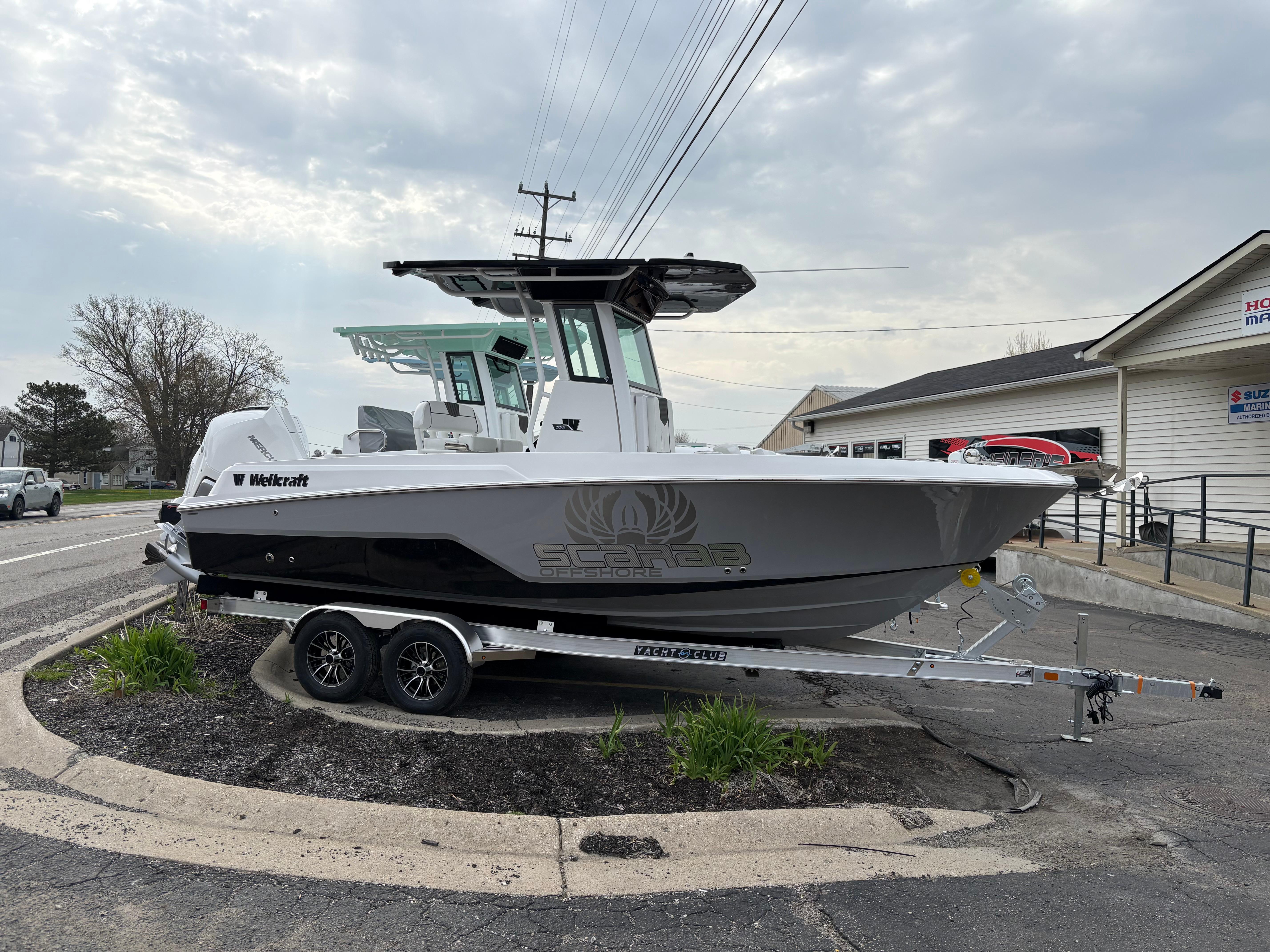 Wellcraft 223 Fisherman 2025 Wellcraft 223 Fisherman boat on trailer, parked outdoors under cloudy sky.
