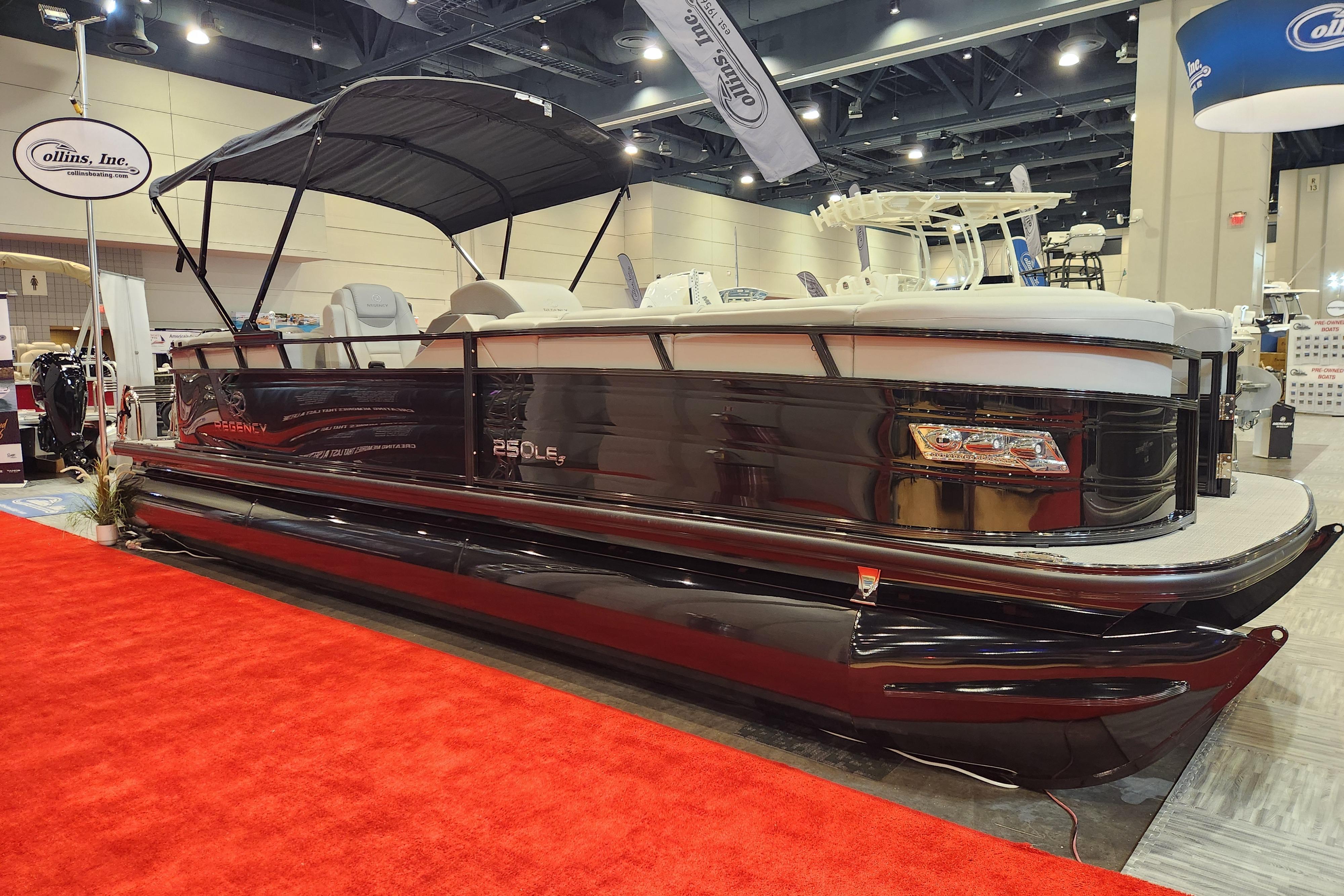 Regency 250 LE3 2025 Regency 250 LE3 pontoon boat displayed indoors on red carpet.