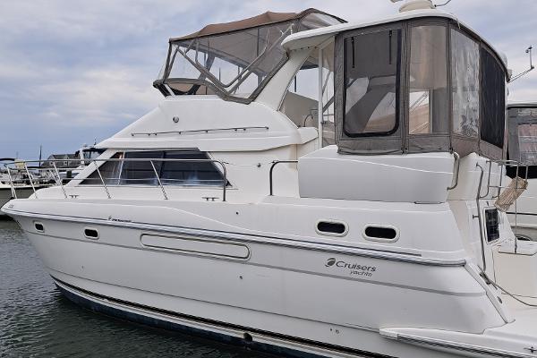 Cruisers aft cabin 1999 Cruisers aft cabin yacht docked at marina, featuring sleek design and spacious upper deck.