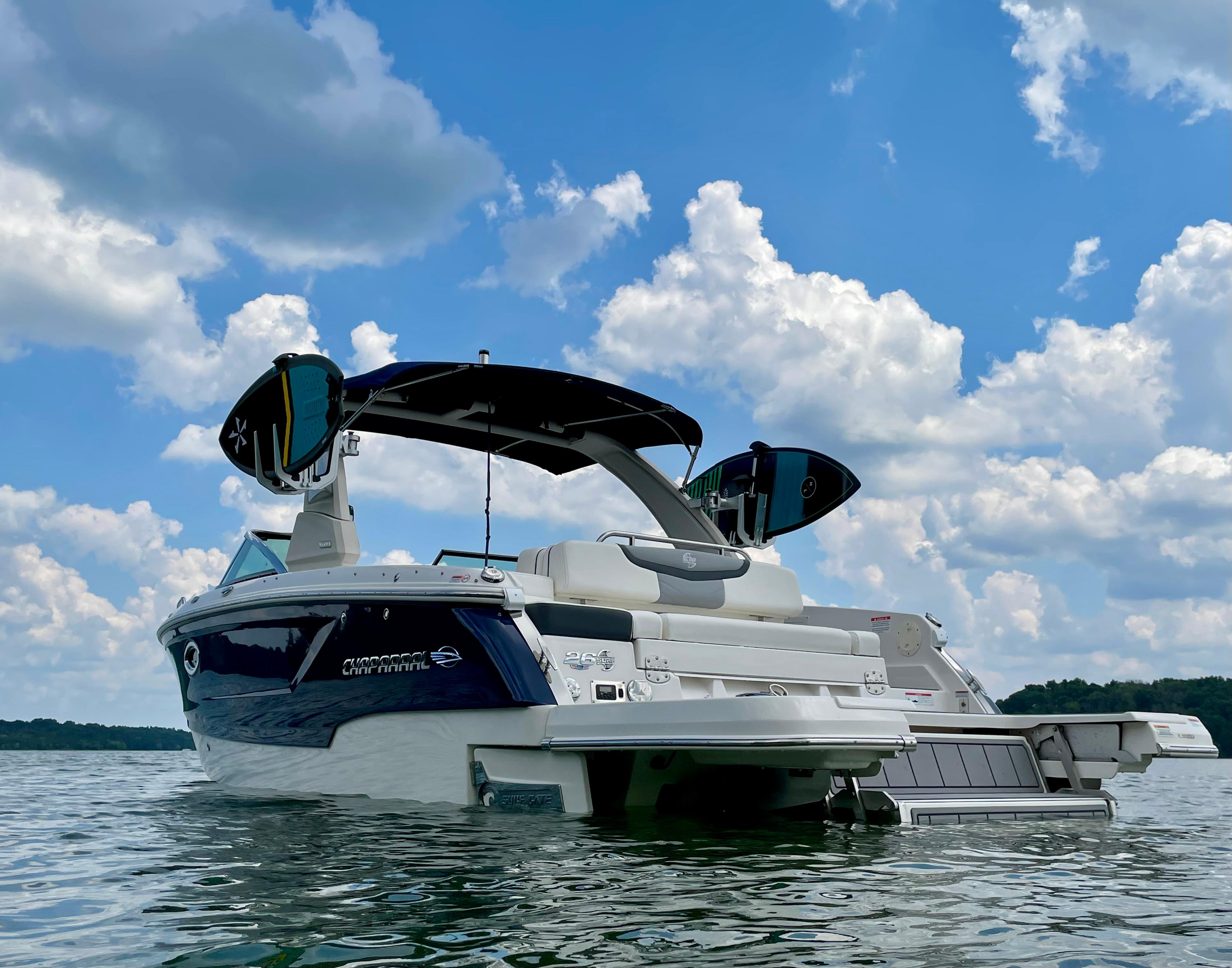 Chaparral 26 Surf 2022 Chaparral 26 Surf boat on water under a cloudy blue sky.