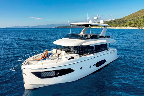 Absolute 52 Navetta 2025 Absolute 52 Navetta yacht cruising on blue ocean near scenic coastline.