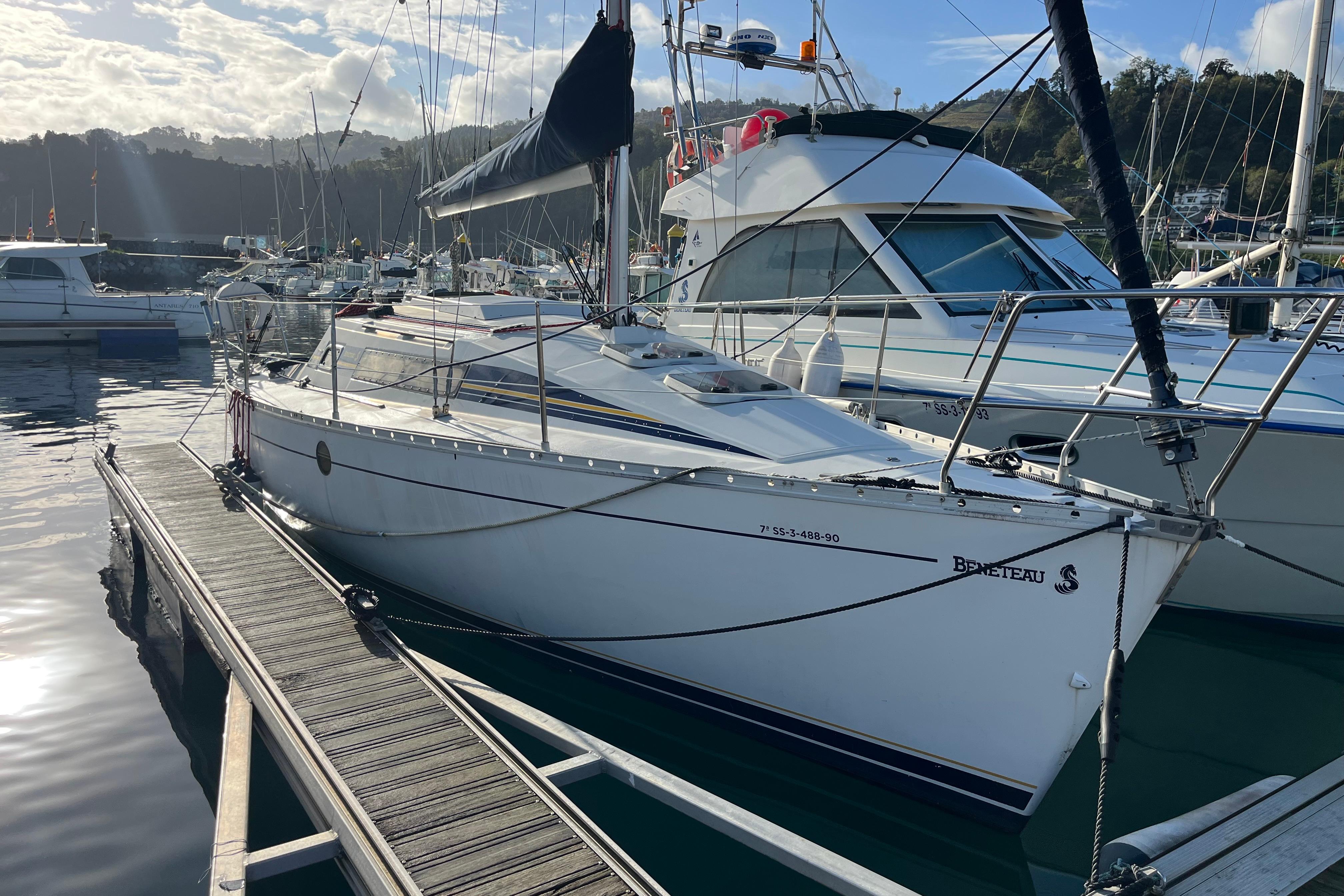 Beneteau First 285 1990 Beneteau First 285 sailboat docked in a marina under a partly cloudy sky.