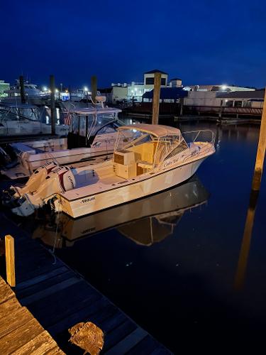 Mako 250 Walk Around 1988 Mako 250 Walk Around boat docked at night, reflecting on calm water.