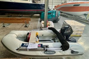 West Marine RIB 275 AL WHT 2018 West Marine RIB 275 AL inflatable boat in storage with Tohatsu outboard motor.