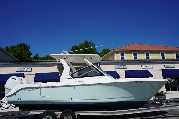 Edgewater 262 CX 2018 Edgewater 262 CX boat on trailer, parked in front of a building with blue awnings.