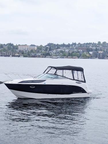 Bayliner 255 SB 2010 Bayliner 255 SB boat on a calm lake with cityscape background.