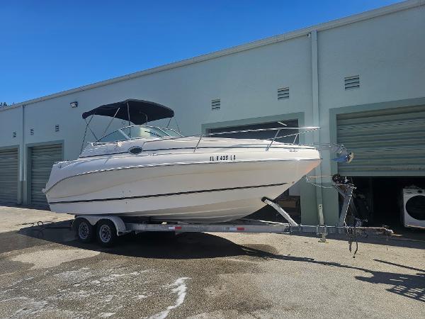 Rinker 242 Fiesta Vee 2002 Rinker 242 Fiesta Vee boat on trailer, parked outside storage units.