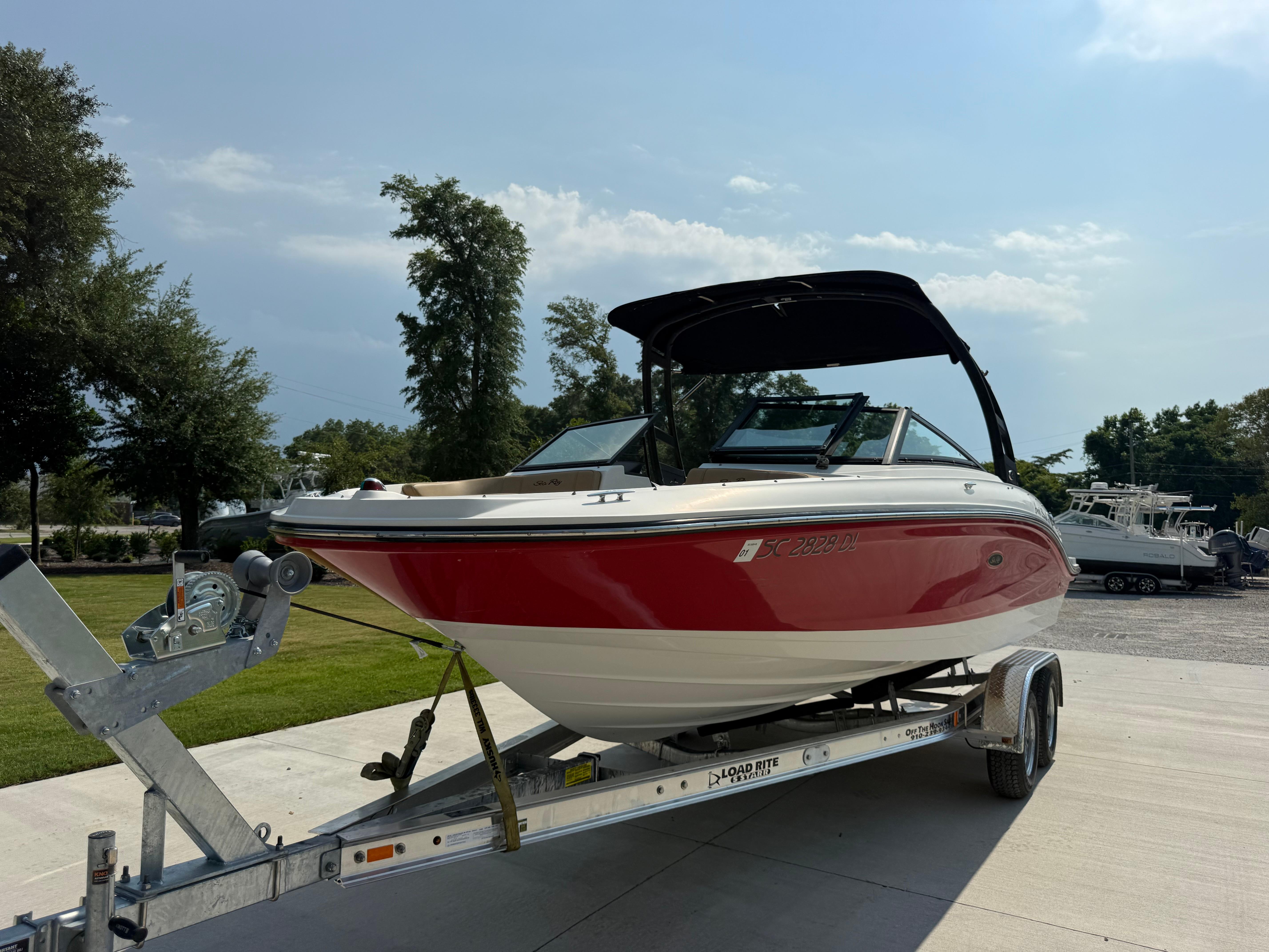 Sea Ray 21 SPX 2019 Sea Ray 21SPX boat on trailer, red and white, parked outdoors.