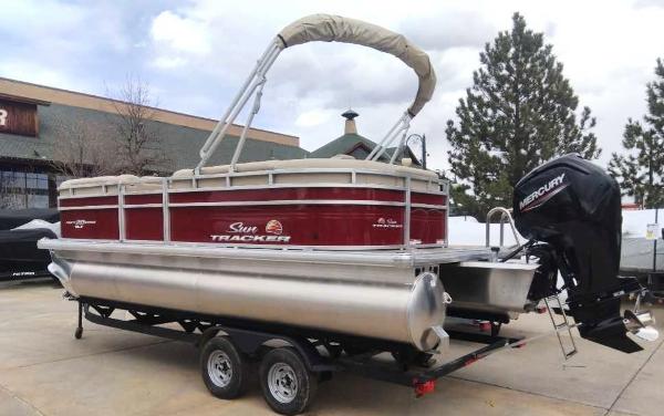 Sun Tracker Party Barge 20 DLX 2025 Sun Tracker Party Barge 20 DLX pontoon boat on trailer, parked outdoors.