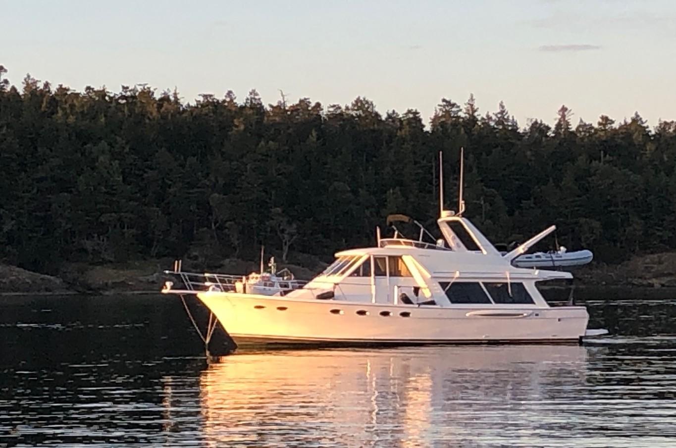 Meridian 490 Pilothouse Motor Yacht 2003 Meridian 490 Pilothouse Motor Yacht anchored on calm water at sunset.