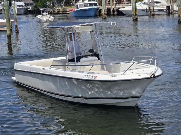 Shamrock 246 Open 1999 Shamrock 246 Open boat cruising in a marina, featuring a sleek white design.