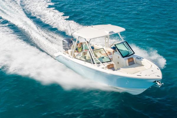 Cobia 240 Dual Console 2024 Cobia 240 Dual Console boat cruising on clear blue water.
