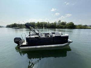 Bennington S Quad Bench 20 SSR 2026 Bennington S Quad Bench 20 SSR pontoon boat on a serene lake.