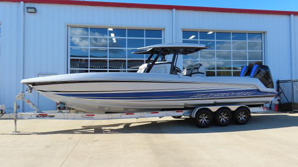 Sunsation 32 CCX 2024 Sunsation 32 CCX boat on trailer, parked outside a building.