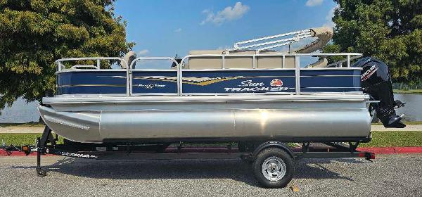 Sun Tracker Bass Buggy 18 DLX 2025 Sun Tracker Bass Buggy 18 DLX pontoon boat on trailer, parked outdoors.