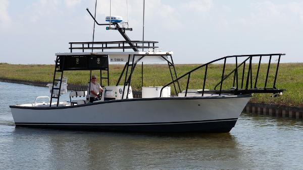 Custom 31 Center Console 1997 Custom 31 Center Console boat cruising on a calm waterway.