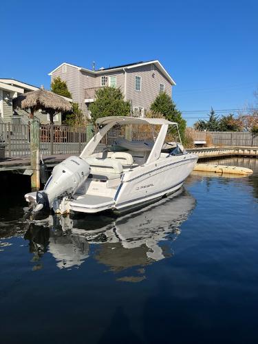 Regal 26 OBX 2020 Regal 26 OBX boat docked near waterfront homes.