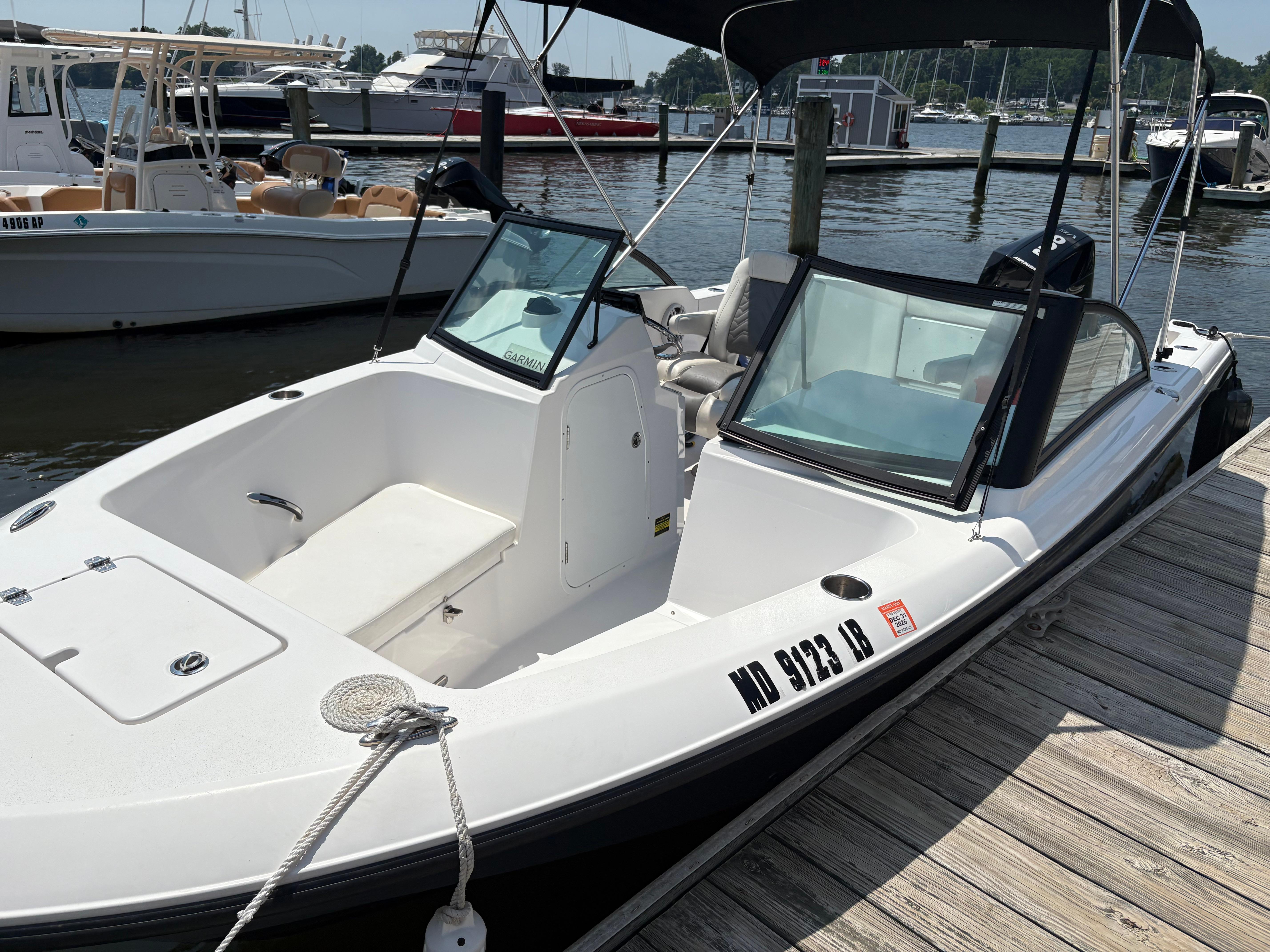 Aquasport 2200 Dual Console 2023 Aquasport 2200 Dual Console boat docked at marina, featuring sleek design and spacious seating.